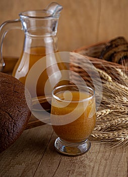 Homemade bread kvass. Summer carbonated soft drink. Glass and carafe on a wooden table. Black Overseas Rye Bread - Ingredients for