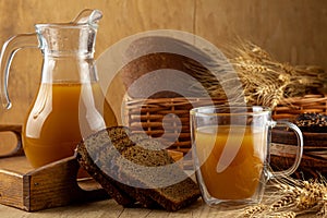 Homemade bread kvass. Summer carbonated soft drink. Glass and carafe on a wooden table. Black Overseas Rye Bread - Ingredients for