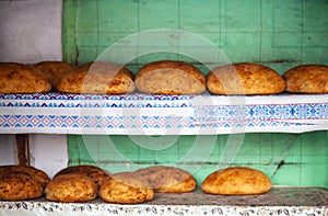 Homemade bread loafs resting on a wooden bench with plastic mat in Viscri, RO