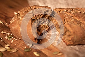 Homemade bread and pumpkin seeds on parchment paper on wooden table