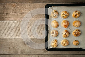 The homemade bread rolls with sesame seeds hamburger with sesame, pumpkin, flax, sunflower seeds on the tray, concept of burger