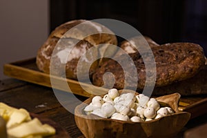 Homemade breads and assorted cheeses exposed on the wooden table