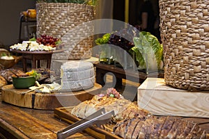 Homemade breads and assorted cheeses exposed on the wooden table