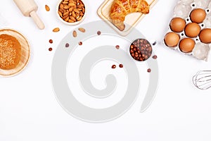 Homemade breads or bun, croissant and bakery ingredients, flour, almond nuts, hazelnuts, eggs on white background, Bakery