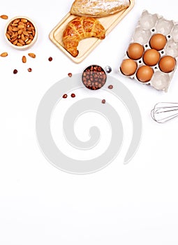 Homemade breads or bun, croissant and bakery ingredients, flour, almond nuts, hazelnuts, eggs on white background, Bakery