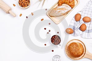 Homemade breads or bun, croissant and bakery ingredients, flour, almond nuts, hazelnuts, eggs on white background, Bakery backgrou
