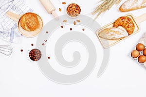 Homemade breads or bun, croissant and bakery ingredients, flour, almond nuts, hazelnuts, eggs on white background, Bakery