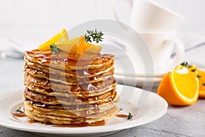 Homemade breakfast or brunch: american style pancakes served with orange and sprinkled syrup