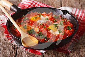 Homemade breakfast shakshuka of fried eggs with tomato close-up. horizontal