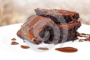 Homemade brownie served with chocolate fudge. Sweet dessert on wooden background