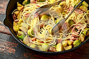 Homemade Brussels sprouts, bacon, pancetta pasta with parmesan cheese. On wooden table