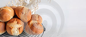 homemade buns. Homemade buns on a wooden board with wheat ears. Homemade buns for dinner, boiled with vegetable milk.