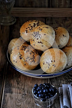 Homemade buns with linseed sunflower seeds for breakfast with butter and blueberry jam