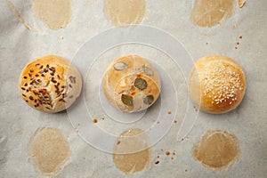 Homemade burger bun on bakery parchment . Food photography, concept of homemade fresh bakery. Rolls with sesame seeds hamburger wi