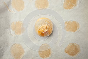 Homemade burger bun on bakery parchment . Food photography, concept of homemade fresh bakery. Rolls with sesame seeds hamburger