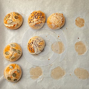 Homemade burger bun on bakery parchment . Food photography, concept of homemade fresh bakery. Rolls with sesame seeds hamburger wi