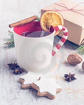 Homemade butter nuts star shaped cookies with icing, pine, orange slices,cinnamon, anise and walnuts over white wood background.