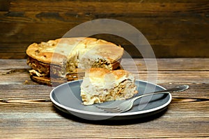 homemade cabbage pie, piece of tart on plate on wooden rustic table. cooking baking pastry receipe. Autumn winter