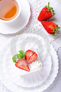 Homemade cake, Strawberry Shortcake on white plate with tea and decorated with strawberries giving the feeling of the morning