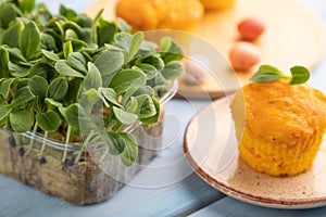 Homemade cakes with chocolate eggs and borage microgreen on a blue, side view, selective focus