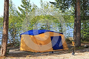 A homemade camping sauna from an old tent on the shore of a forest lake. Republic of Karelia, Russia.