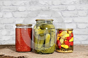 Homemade canned food. Pickled snacks for the winter. Pickled cucumbers, Italian tomatoes in their own juice and mini chili peppers