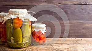 Homemade canned vegetables in cans. Pickled tomatoes and cucumbers in a rural style. Copy space