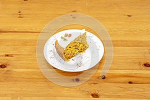 Homemade carrot cake with nuts, cinnamon, raisins and sunflower seeds on white plate