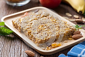 Homemade Cereal granola bars with nuts and garnola, milk bottle, apple, banana on wooden desk, Energy food, Healthy snack