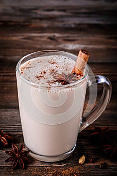 Homemade Chai Tea Latte with anise and cinnamon stick in glass mug