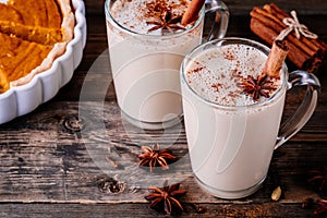 Homemade Chai Tea Latte with anise and cinnamon stick in glass mugs with pumpkin pie