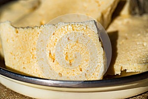 Homemade cheese Bryndza cut in slices in bowl close