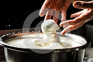 The homemade cheese maker produces handmade mozzarella with fresh bio milk. process of making mozzarella. Italian hard cheese
