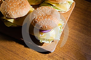 Homemade cheeseburgers on a wooden tray