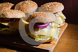 Homemade cheeseburgers on a wooden tray