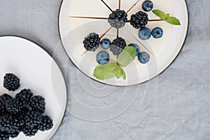 Homemade cheesecake with fresh berries. a piece of cheesecake with a blackberry in the foreground