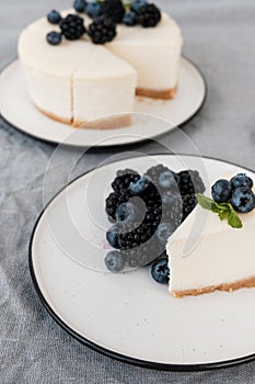 Homemade cheesecake with fresh berries. a piece of cheesecake with a blackberry in the foreground