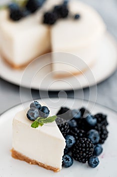 Homemade cheesecake with fresh berries. a piece of cheesecake with a blackberry in the foreground