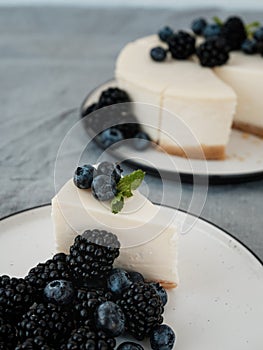 Homemade cheesecake with fresh berries. a piece of cheesecake with a blackberry in the foreground