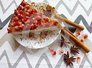 Homemade cheesecake with pomegranate and cinnamon sticks and anis stars