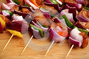 Homemade Chicken and Bacon Skewers Kebabs with Peppers Onions and Herb Marinate on wooden background