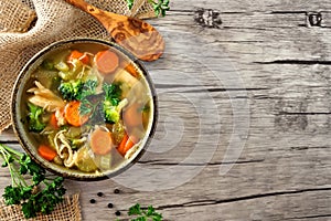 Homemade chicken vegetable soup, above side border on rustic wood