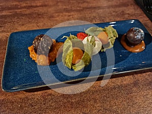 Homemade chocolate balls with different berry fillings on a blue ceramic plate