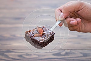 Homemade chocolate brownie with almond on teaspoon