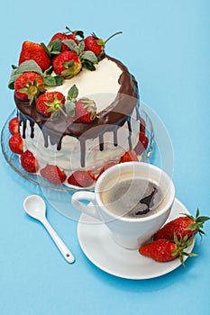 Homemade chocolate cake decorated with fresh strawberries on glass plate and cup of coffee with saucer