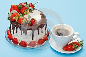 Homemade chocolate cake decorated with fresh strawberries on glass plate and cup of coffee with saucer