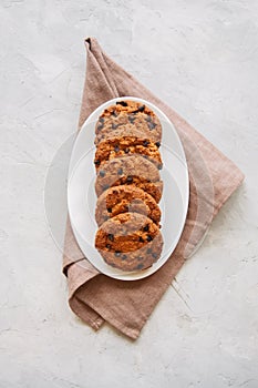 Homemade chocolate chip cookies in a plate on a white stone back