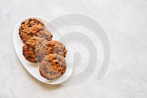 Homemade chocolate chip cookies in a plate on a white stone back