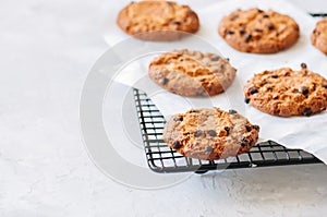 Homemade chocolate chips cookies on a wire rack on a white stone