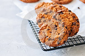 Homemade chocolate chips cookies on a wire rack on a white stone